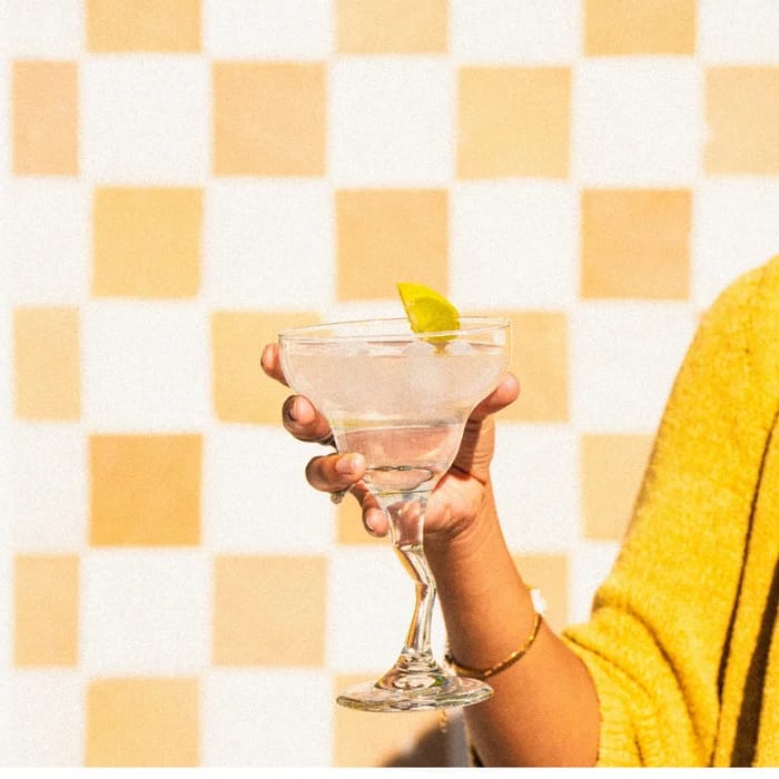 A hand holding a sparkling Shroom Soda® mocktail