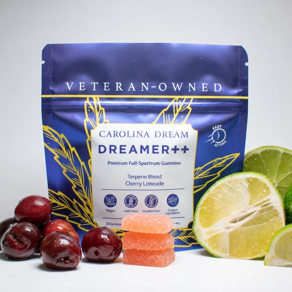 A pouch of Carolina Dream Dreamer++ gummies surrounded by fresh cherries and limes.