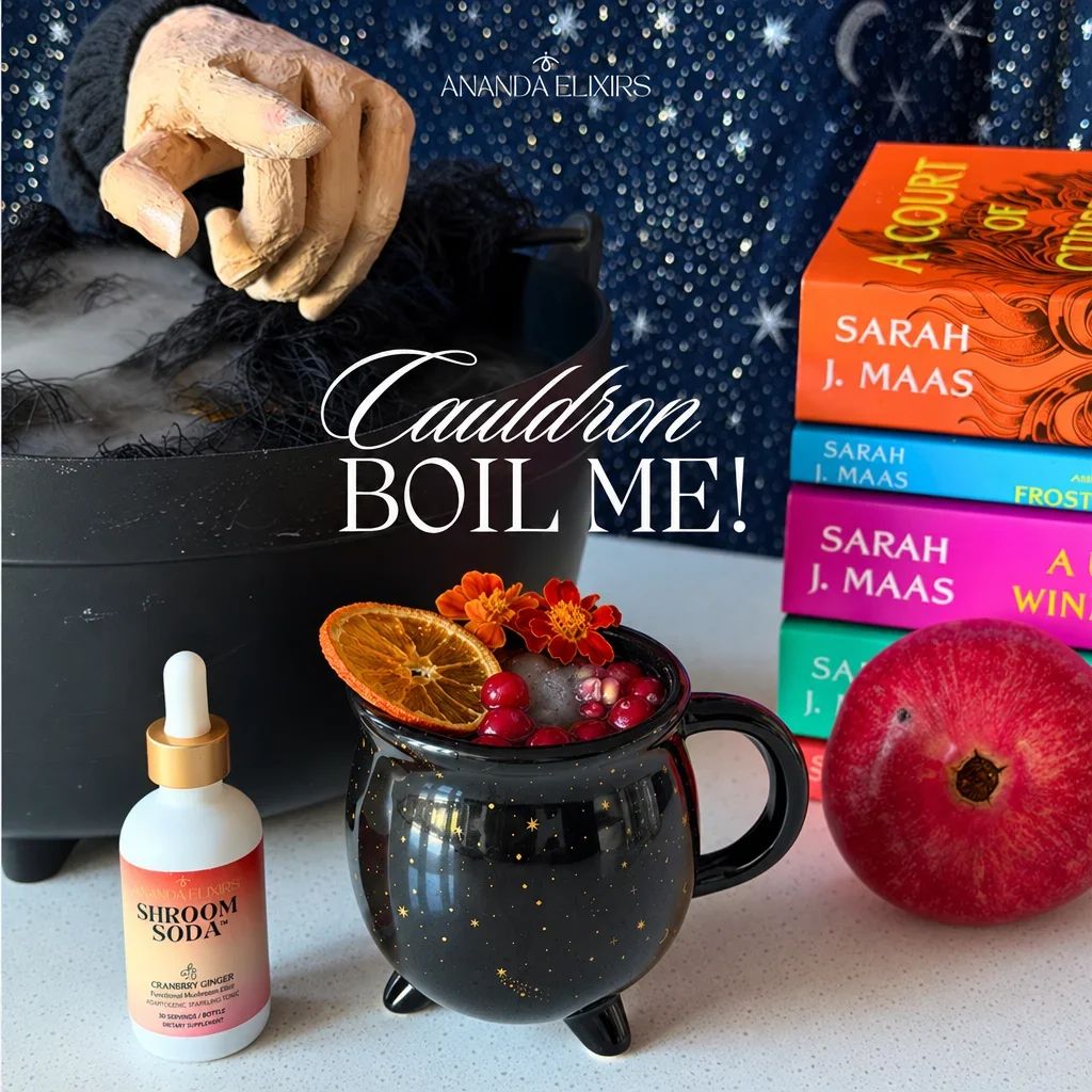 A spooky black cauldron mug filled with a drink sits beside a Shroom Soda bottle.
